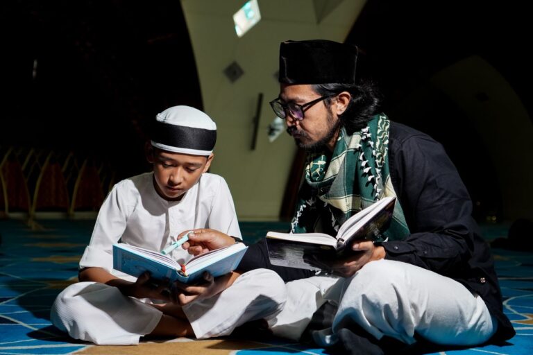Crafting Captivating Headlines: Your awesome post title goes here A father and son reading religious texts on the floor in a mosque, fostering learning and connection.